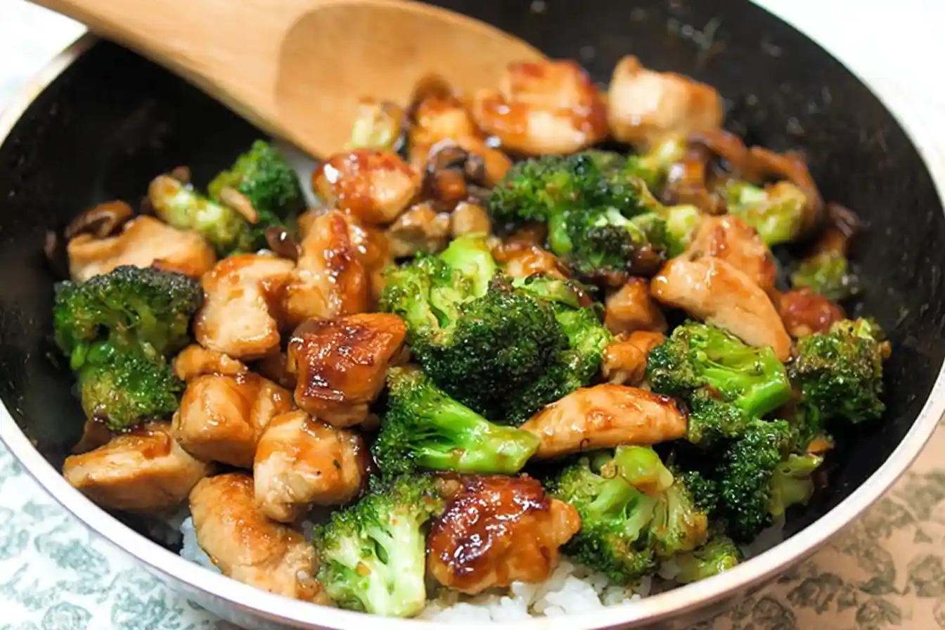 A close-up shot of a vibrant plate of Chicken and Broccoli Stir Fry, generously garnished with sesame seeds, ready to be enjoyed.