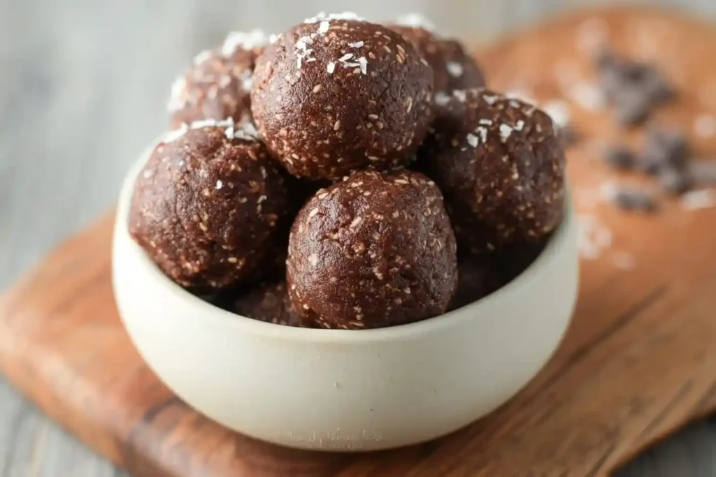 A close-up of a white bowl filled with chocolate {{ $('Fetch Recipe Data').first().json["Main Keyword"] }} sprinkled with shredded coconut.