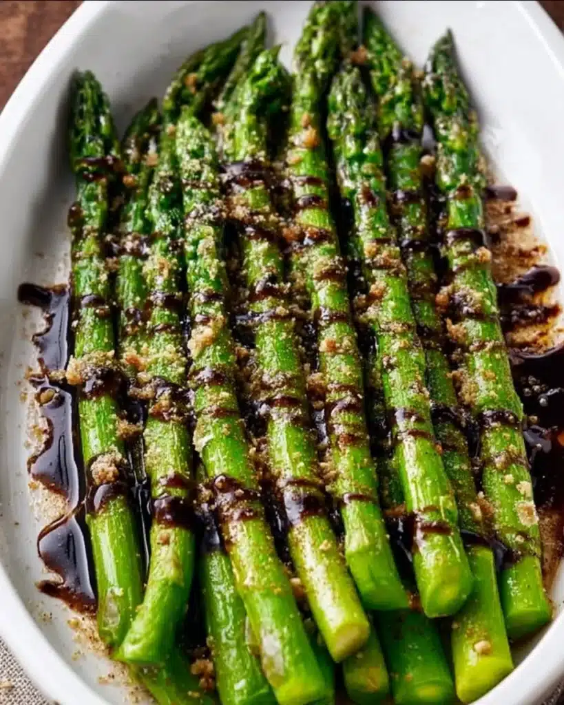 Plate of flavorful asparagus with balsamic glaze drizzled on top