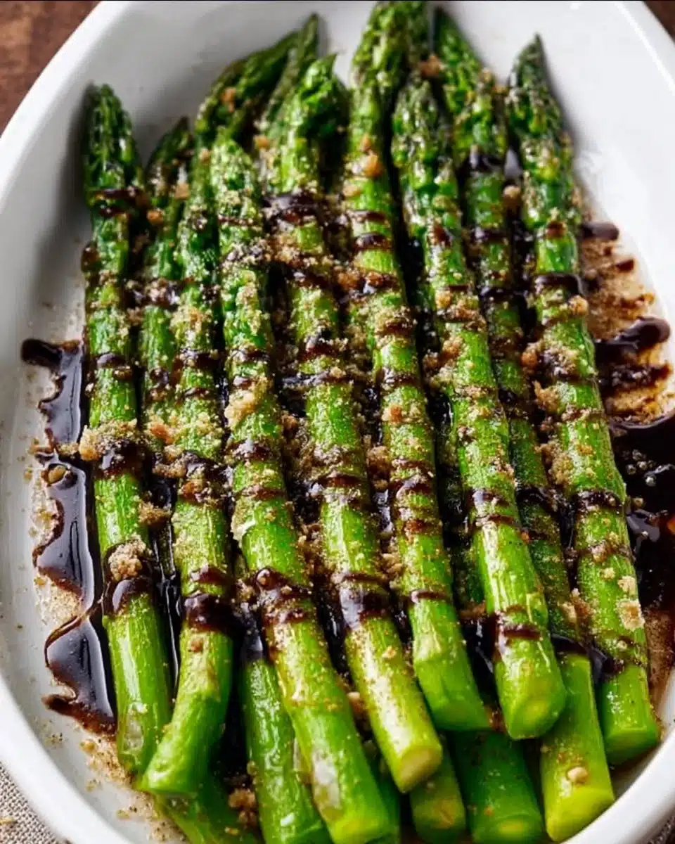 Plate of flavorful asparagus with balsamic glaze drizzled on top